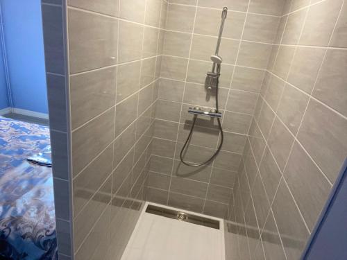 a shower with a hose in a tiled bathroom at The Splendid View - 8 Personnes in Bouillon