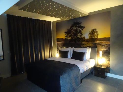 a bedroom with a bed with a painting on the wall at B & B De Elsterberg in Elst