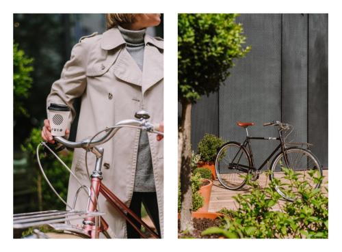 a woman in a trench coat and a bike at PURO Warszawa Centrum in Warsaw