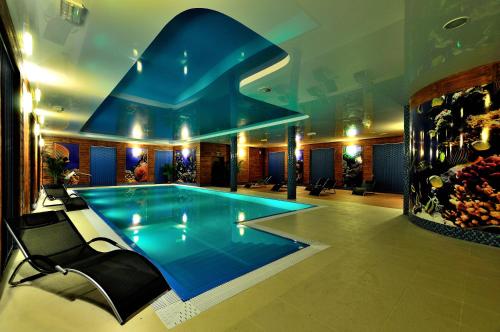 a large swimming pool in a building with a blue pool at HOTEL NIAGARA in Konin