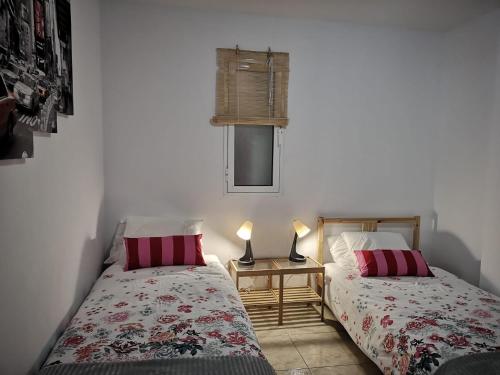 een slaapkamer met 2 bedden en een tafel met 2 lampen bij IT HOME - 2 Private Apartments in Telde