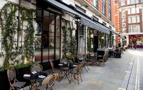 a group of tables and chairs outside of a restaurant at The Marylebone Hotel in London