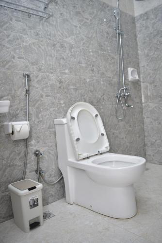 uma casa de banho com um WC branco e um chuveiro em Hancol Hotel em Dodoma