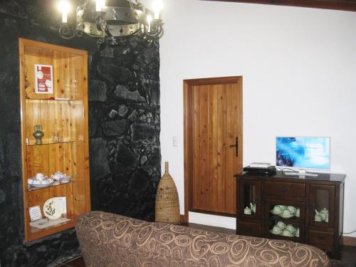 a living room with a couch and a stone wall at Casa Santana in Nordeste