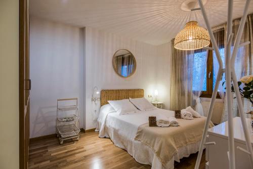 biała sypialnia z łóżkiem i lustrem w obiekcie APARTAMENTO MOIRA en Bielsa w mieście Bielsa