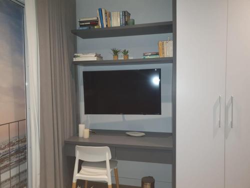 a computer desk with a monitor and a white chair at Woodstock Studio Apartments in Cape Town