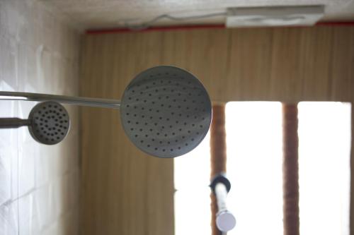 a shower head hanging from a pole in a room at Fort Guesthouse نُزل القلعة in Muscat