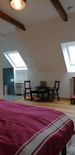 a room with a bed and two chairs and a table at Le Derrien in La Roche-Derrien