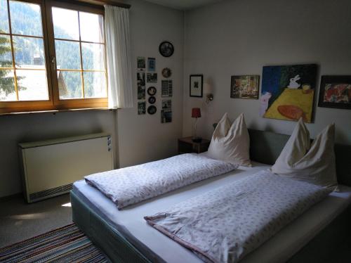 1 dormitorio con 2 camas con almohadas y ventana en Müllershus, en Langwies