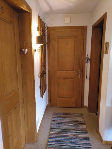 a hallway with a wooden door and a rug at Müllershus in Langwies