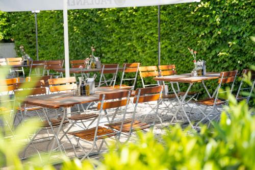 a group of tables and chairs under an umbrella at Hotel Olympia Schießanlage in Garching bei München