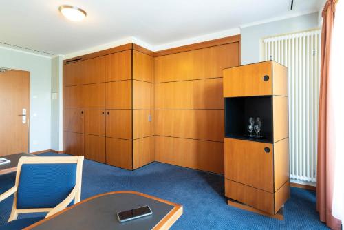 a room with wooden cabinets and a table and chairs at Seminaris Hotel Potsdam Griebnitzsee in Potsdam