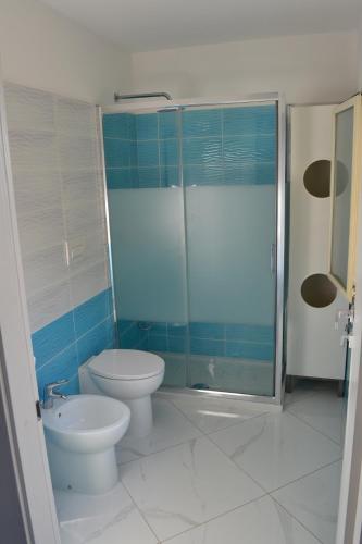 a bathroom with a toilet and a glass shower at DEPANDANCE SUL MARE in Sperlonga