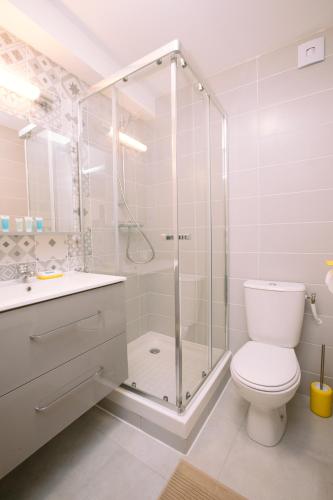 une salle de bain blanche avec douche et toilettes dans l'établissement Duplex avec terrasse - hyper-centre de Toulon, à Toulon