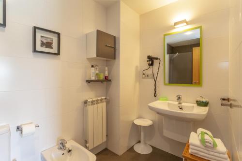 une salle de bain avec un lavabo, des toilettes et un miroir dans l'établissement Apartamentos Turísticos Playa de Tapia, à Tapia de Casariego