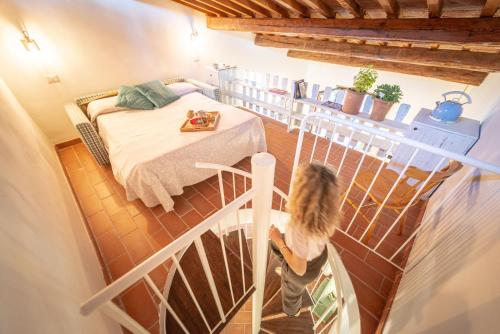 a woman standing in a room with a bed at Tenuta di Poggio Cavallo in Istia dʼOmbrone