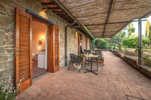an outdoor patio with a table and chairs and a building at Tenuta di Poggio Cavallo in Istia dʼOmbrone