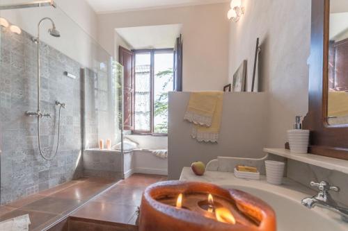 a bathroom with a tub with a shower and a sink at Tenuta di Poggio Cavallo in Istia dʼOmbrone