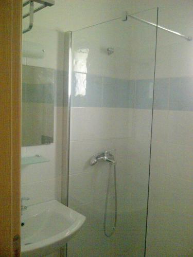 a shower with a glass door next to a sink at Thalassa Studios in Faliraki