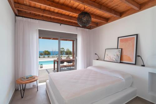 sypialnia z łóżkiem i widokiem na basen w obiekcie Terra d'Oro Sea view villa with private pool w mieście Kiotari
