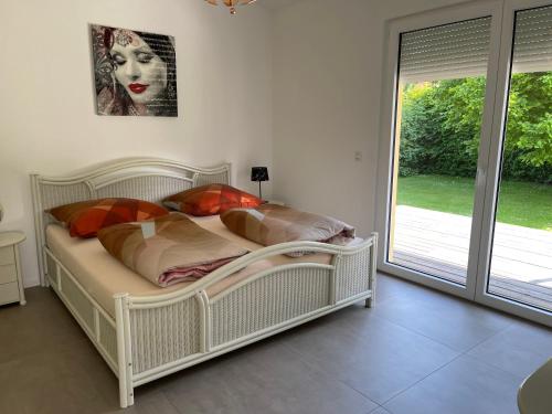 a white bed in a room with a window at FEWO Sunshine in Villingen-Schwenningen