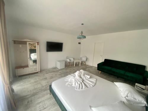 ドゥボバにあるCasa Nicoleのベッドルーム(白いベッド1台、緑のソファ付)