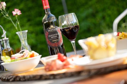 a bottle of wine sitting next to a plate of food at Hotel Olympia Schießanlage in Garching bei München