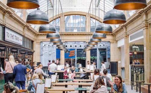 a large building with people sitting at tables in a library at Fulham Broadway 2-Bed Apt w Garden & Pets Ok in London