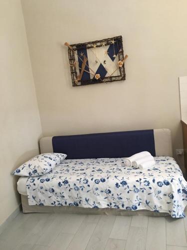 a bedroom with a bed with a blue and white comforter at Da zio Totò in Scilla