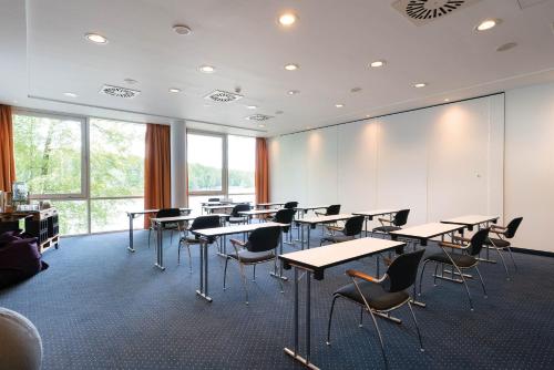 a classroom with desks and chairs in a room with windows at Seminaris Hotel Potsdam Griebnitzsee in Potsdam