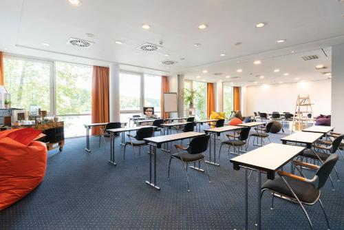 a classroom with desks and chairs in a room with windows at Seminaris Hotel Potsdam Griebnitzsee in Potsdam