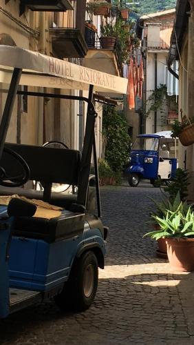 a golf cart parked on a street with a hotel entrance at Da zio Totò in Scilla