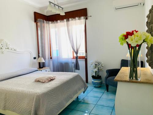a bedroom with a bed and a vase of flowers at Sorrento Moon in Sorrento
