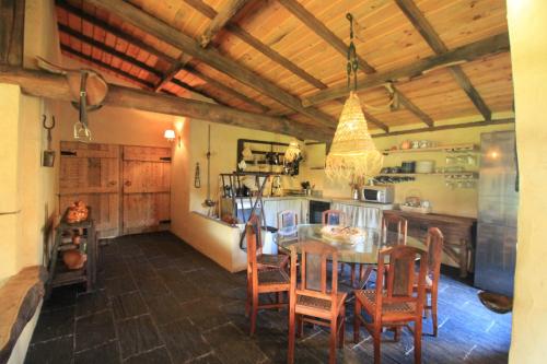 a kitchen and dining room with a table and chairs at Casa de Vilar de Rei, a tranquilidade do mundo rural in Ponte de Lima
