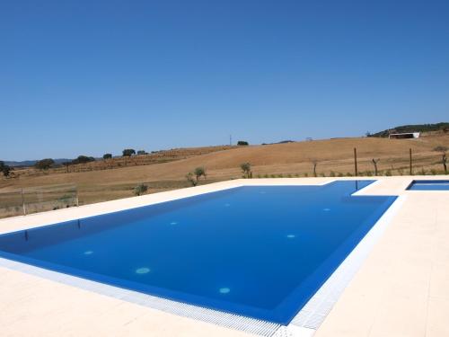 Santa Luzia的住宿－Herdade dos Montes Bastos，一座大型蓝色游泳池,位于一座建筑的顶部