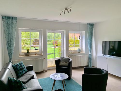 a living room with a couch and chairs and windows at Appartementanlage Lancken-Granitz in Lancken-Granitz
