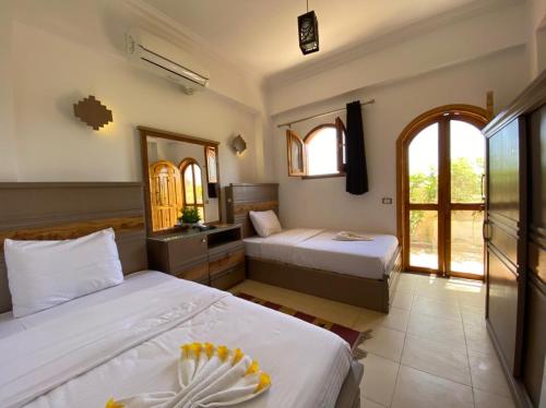 a hotel room with two beds and a mirror at Villa 22 in Dahab