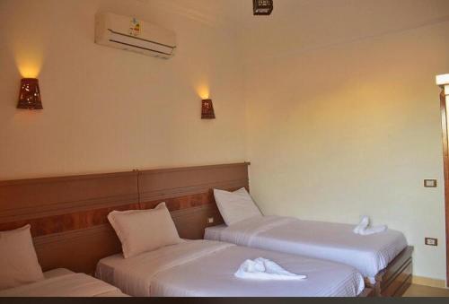 two beds in a hotel room with towels on them at Villa 22 in Dahab