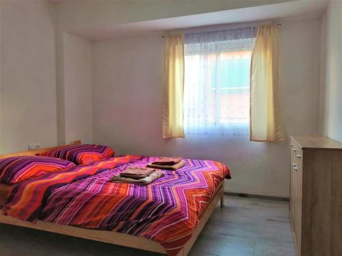a bedroom with a bed with a colorful blanket and a window at Joan Apartment Gandia in Gandía