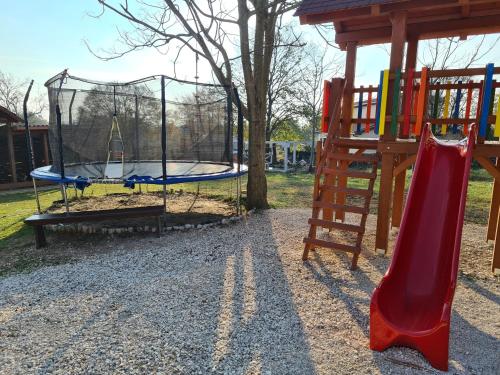 a playground with a slide and a swing at Mobile Homes Dvor in Manjadvorci