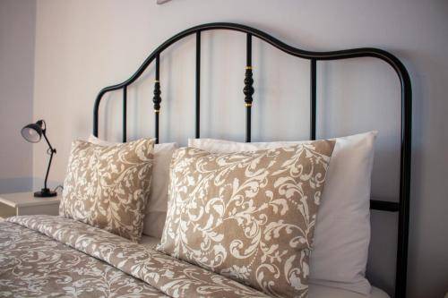 a bed with white pillows and a black head board at Seaview Heights above Portorož in Izola