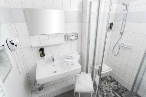 a white bathroom with a sink and a shower at Ferienwohnung Schlossblick in Güstrow