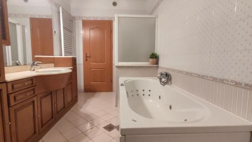 a bathroom with a bath tub and a sink and a tub at Seaview Heights above Portorož in Izola