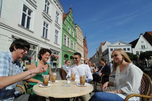 a group of people sitting at a table with drinks at Ferienwohnung Schlossblick in Güstrow