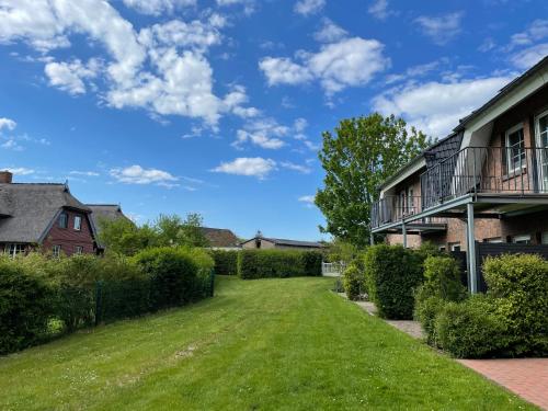 a yard in front of a house with a green lawn at Appartementanlage Lancken-Granitz in Lancken-Granitz