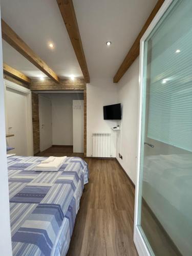 - une chambre avec un lit et une porte coulissante en verre dans l'établissement L'ANTICA FALCONERIA, à Jesi