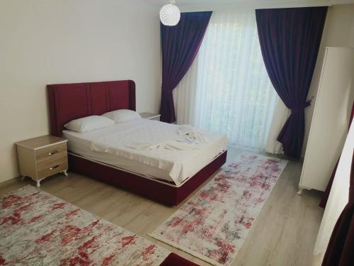 Un dormitorio con una cama y una ventana con cortinas. en Kaya House Daily Flat, en Ortaca