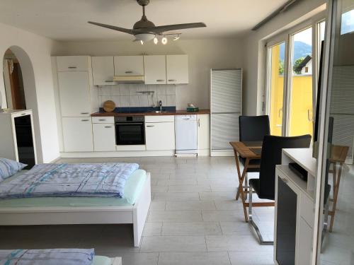 a kitchen with white cabinets and a bed in a room at Terrace Apartment in Klaus