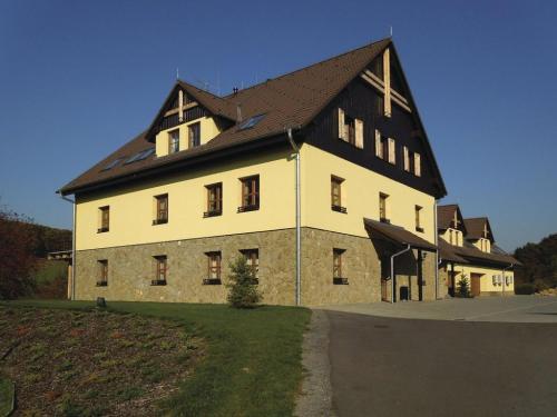 a large white building with a black roof at Penzion Malovaný in Osvětimany