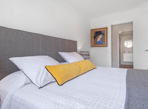- une chambre avec un lit blanc et un oreiller jaune dans l'établissement Principe de Vergara I, à Madrid